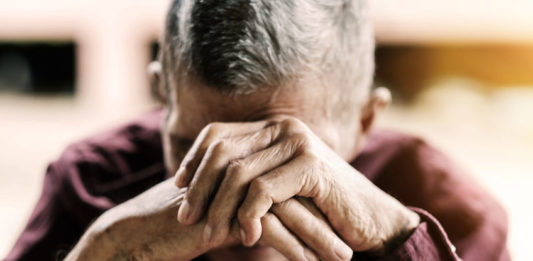 Homme âgé, la tête dans les mains