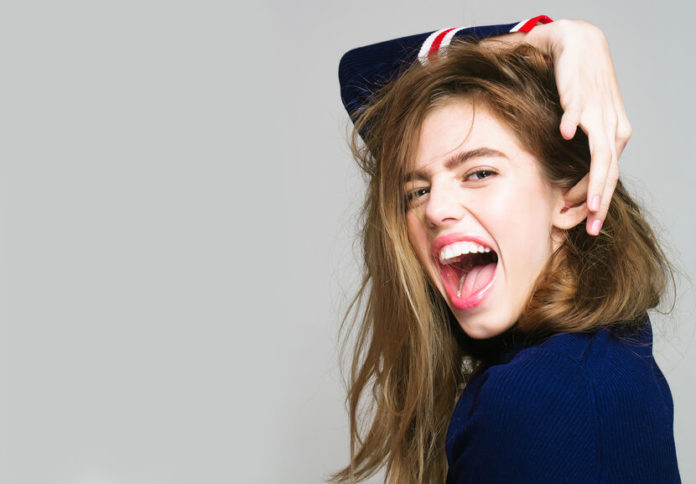 jeune femme aux cheveux longs éclatant de rire