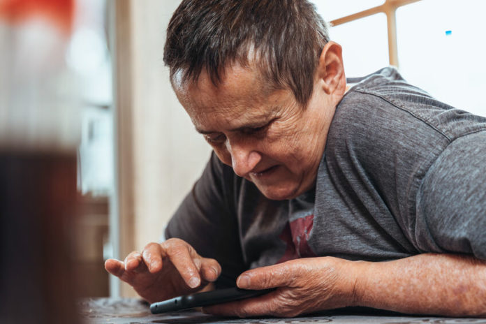 Personne handicapée mentale utilisant son smartphone
