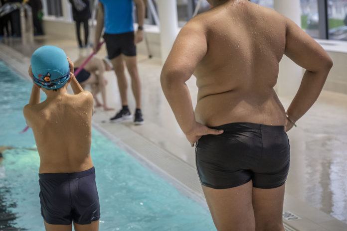 Deux adolescents se preparent a sauter dans l'eau. Photo REA.