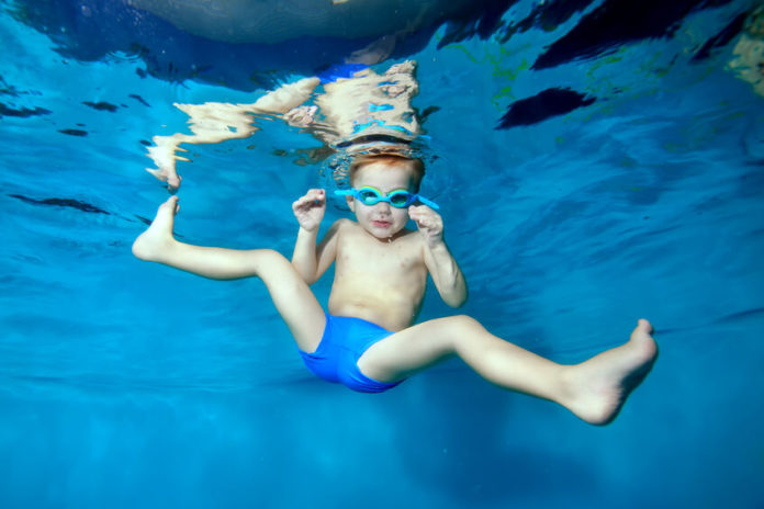 Petit garçon sous l'eau dans une piscine