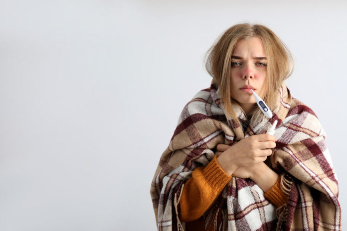 Jeune femme fièvreuse portant un plaid