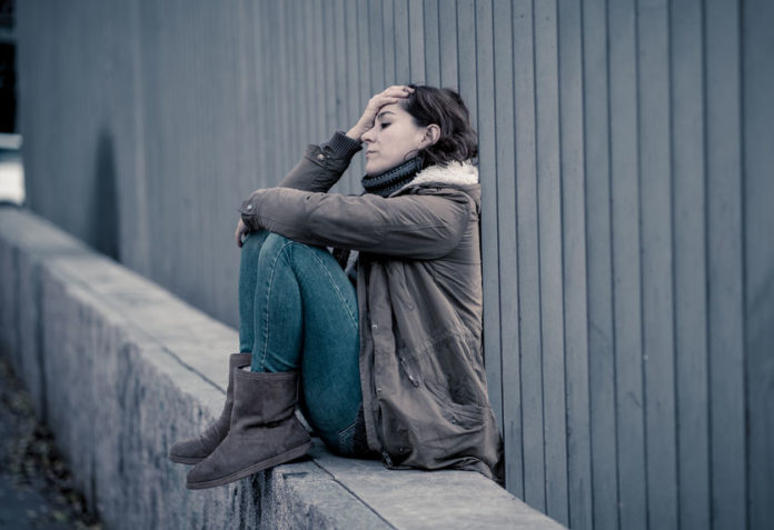 Jeune femme assise triste