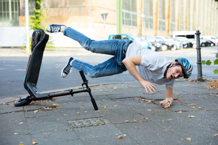 Homme chutant d'une trottinette