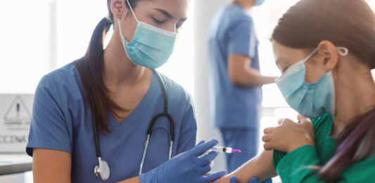 Infirmière vaccinant une jeune écolière