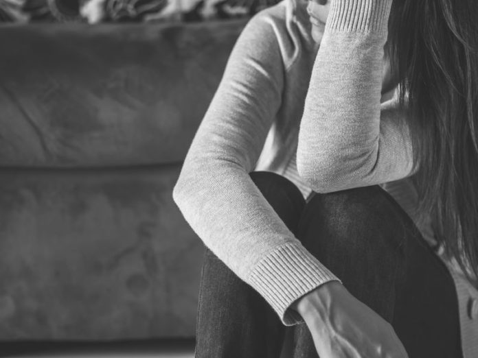 Portrait en noir et blanc d'une femme assise sur un canapé