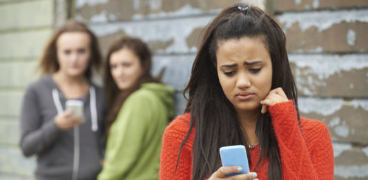jeune fille recevant un message malveillant sur son smartphone